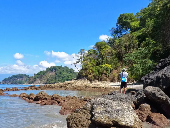 man standing on rocks at Playa Biesanz