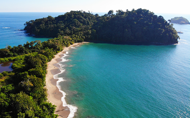 Costa Rica coastline with wavy beach blue water hilly coast