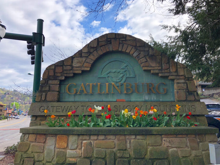 Gatlinburg sign with brick and tulips on sunny day