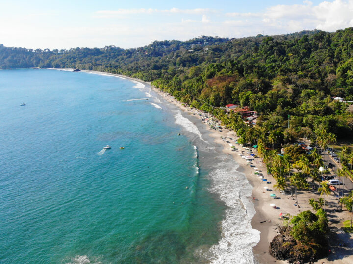 7 days Costa Rica itinerary picture of busy beach aerial view with hilly coastline teal water white waves