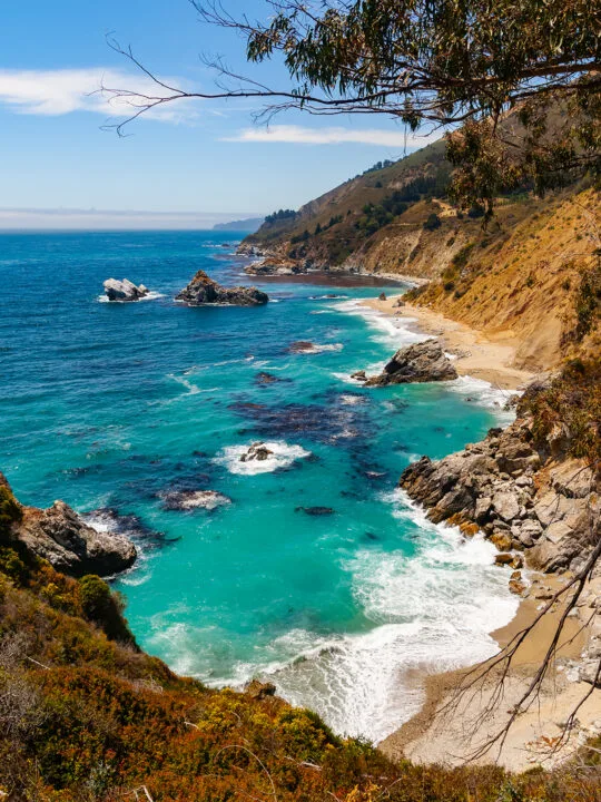 adventure vacations in us view of california coast with teal water rocky shore and white waves