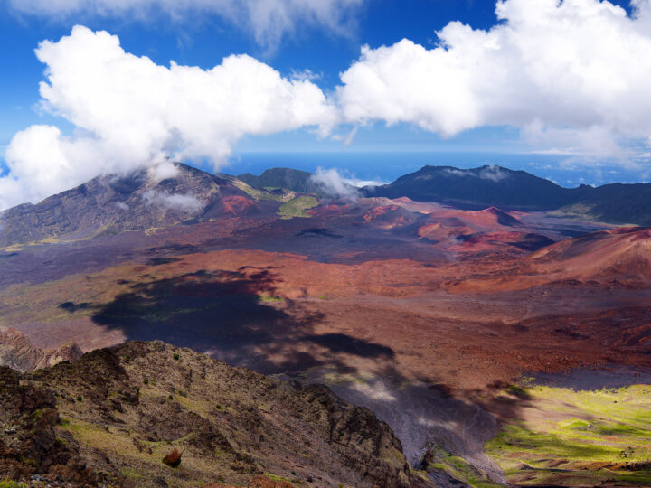 Haleakala at sunset view of inside crater with multicolored dirt bright white clouds