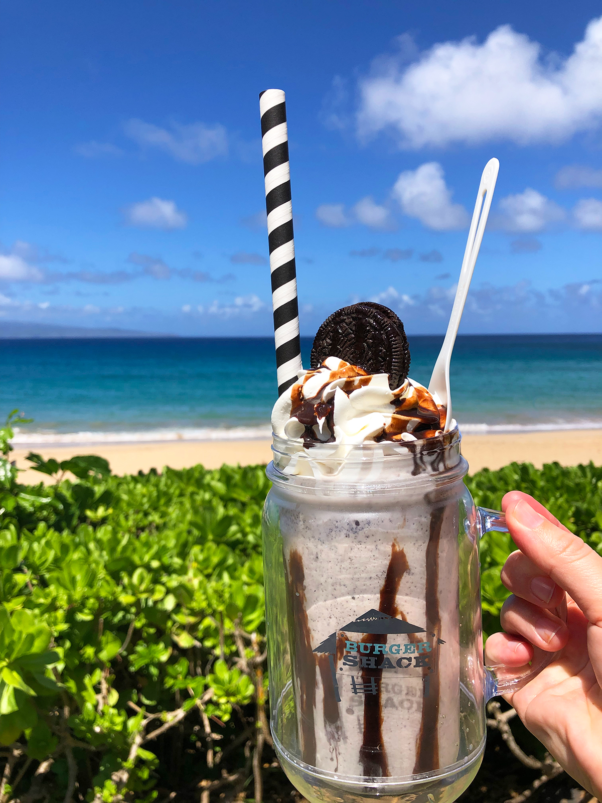 top things to do on maui with kids drinking milkshake next to ocean
