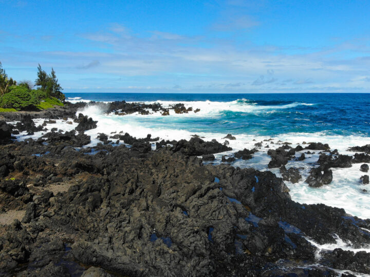things to do with kids in maui see the sights on road to Hana picture of black rocky shore with blue ocean white waves