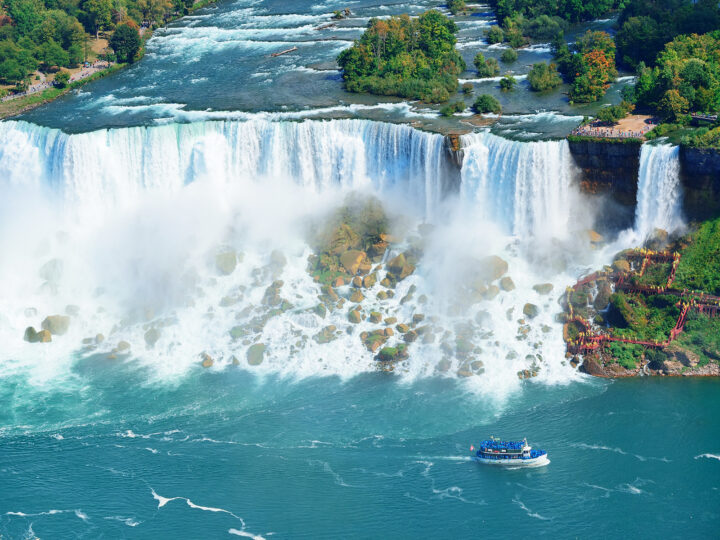 view of Niagara Falls from the air huge waterfall from river tiny boat below one of the best adventure vacations in the US