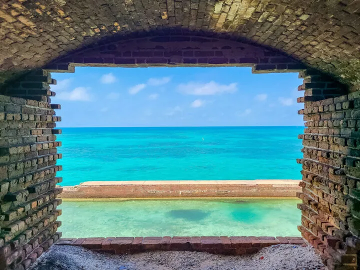 ocean view bright blue water through stone tunnel
