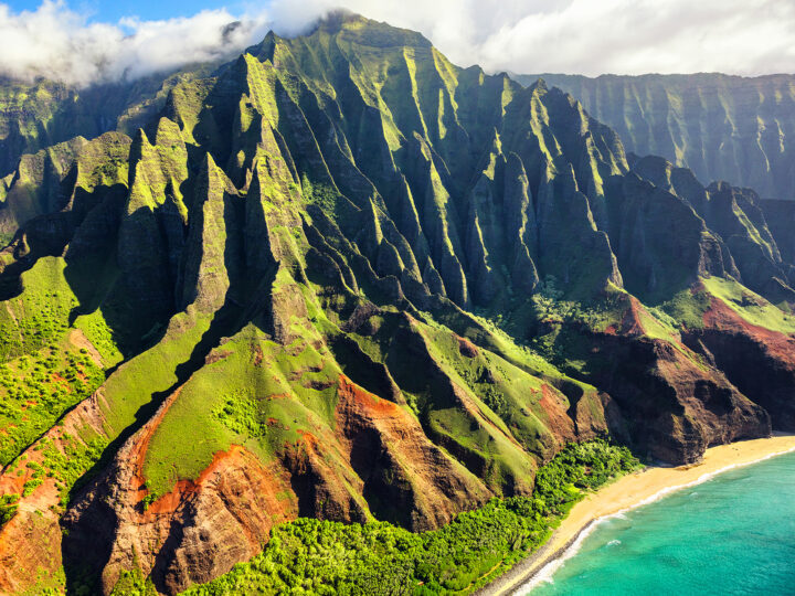 adventures in the US hawaii napali coast jagged mountain peaks green lush forest ocean below