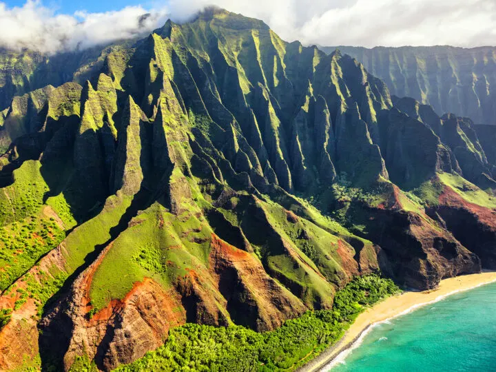 adventures in the US hawaii napali coast jagged mountain peaks green lush forest ocean below