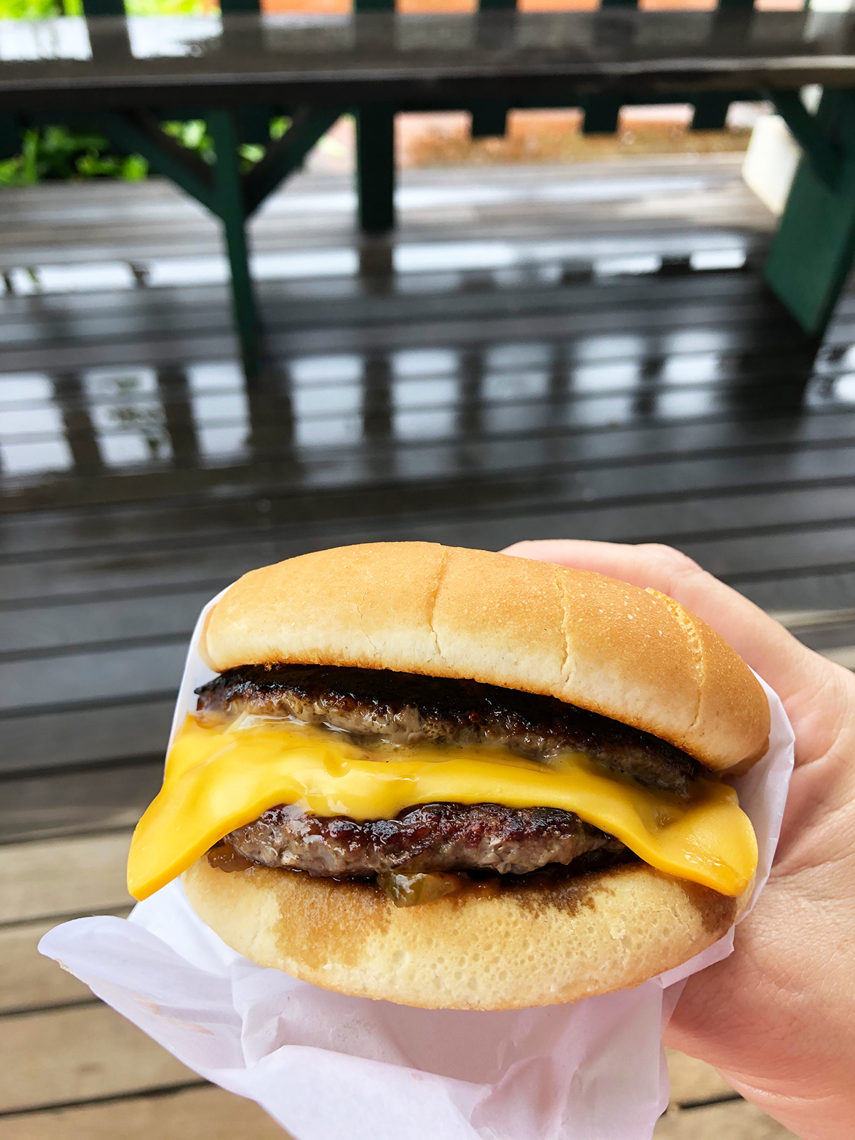 best places to eat in kauai cheeseburger with double patty cheese bun held on balcony