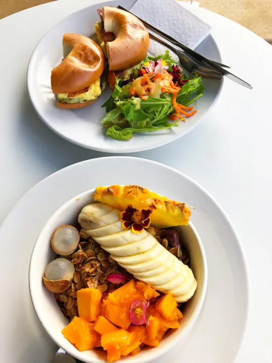 best places to eat in kauai pic of bagel sandwich and salad with fruit spray over granola in bowl