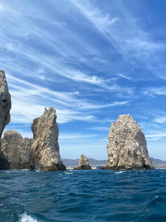 best tropical destinations in December view of ocean with large rocks near Cabo