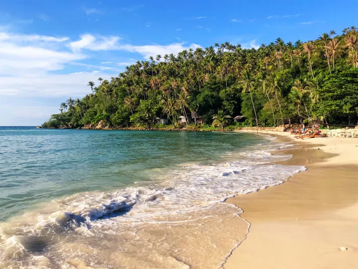 Christmas best destinations view of Thailand beach teal water and palm trees in distance