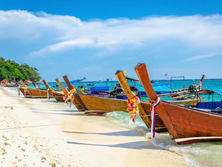 best countries to visit in January view of longboats in Thailand on beach