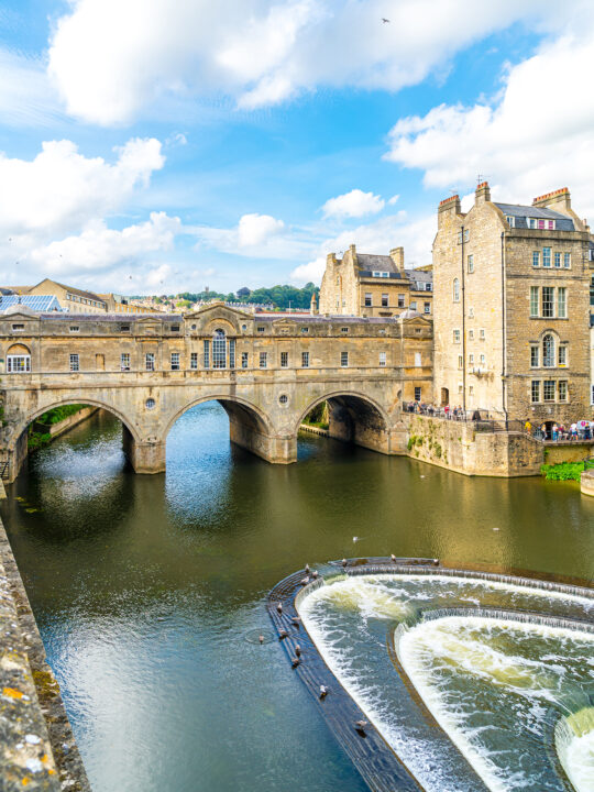 view of England stone bridge over water fountain and building on sunny day