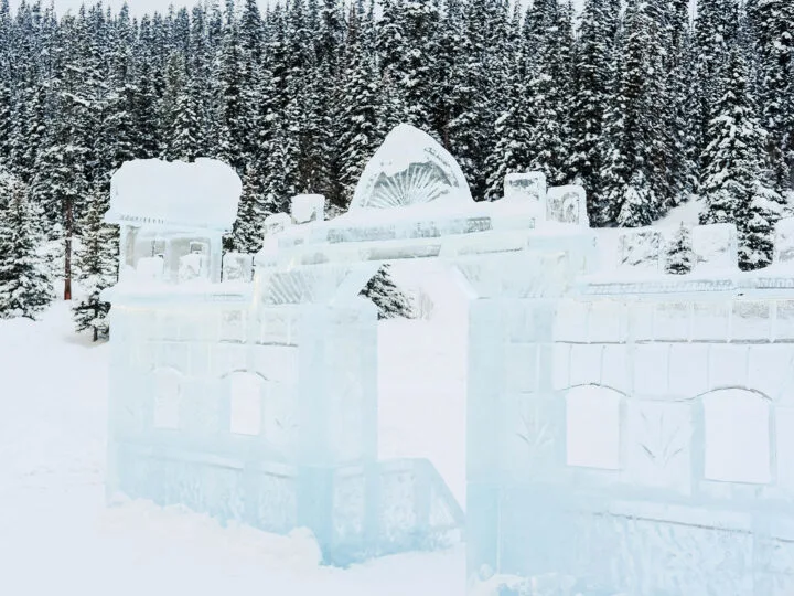ice castle sitting on snow in front of snowy trees in Canada