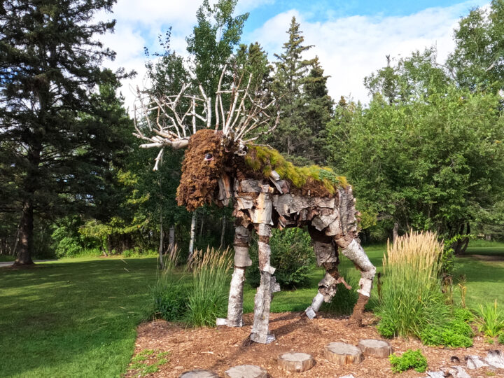 moose statue made of wood in tree area