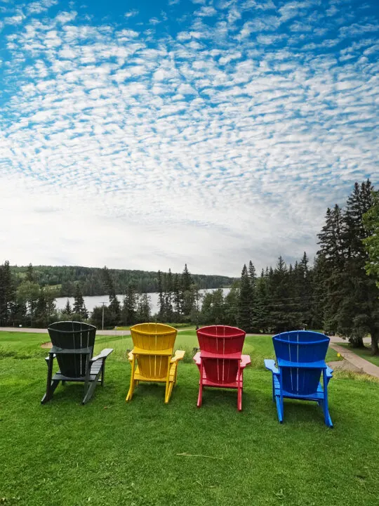 clear lake Manitoba view of four chairs and lake in distance on cloudy day