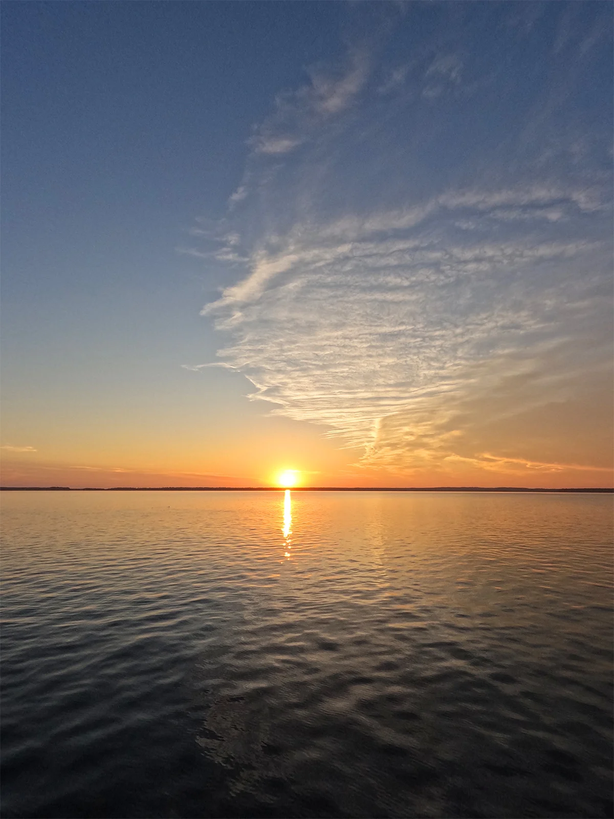 clear lake manitoba at sunset as the sun dips into the lake