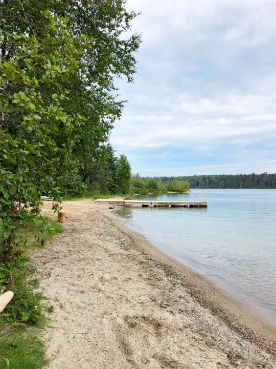 clear lake MB view of deep bay swimming area with beach trees and jumping dock