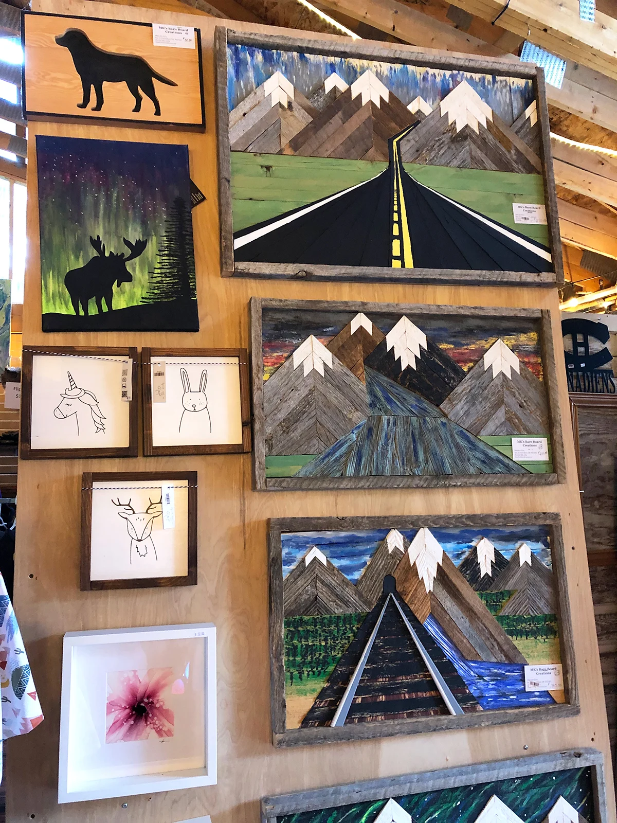 view of woodwork on wall with mountain scenes and animals at a shop