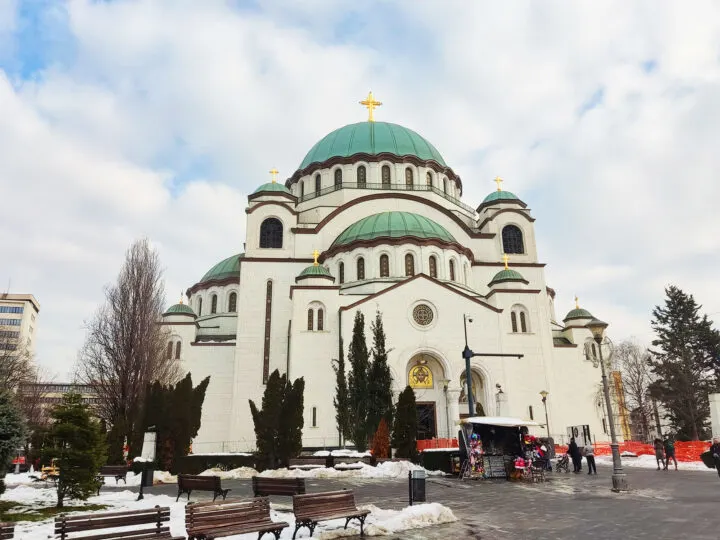 visiting belgrade serbia in the winter view of large church with snow on ground and white clouds