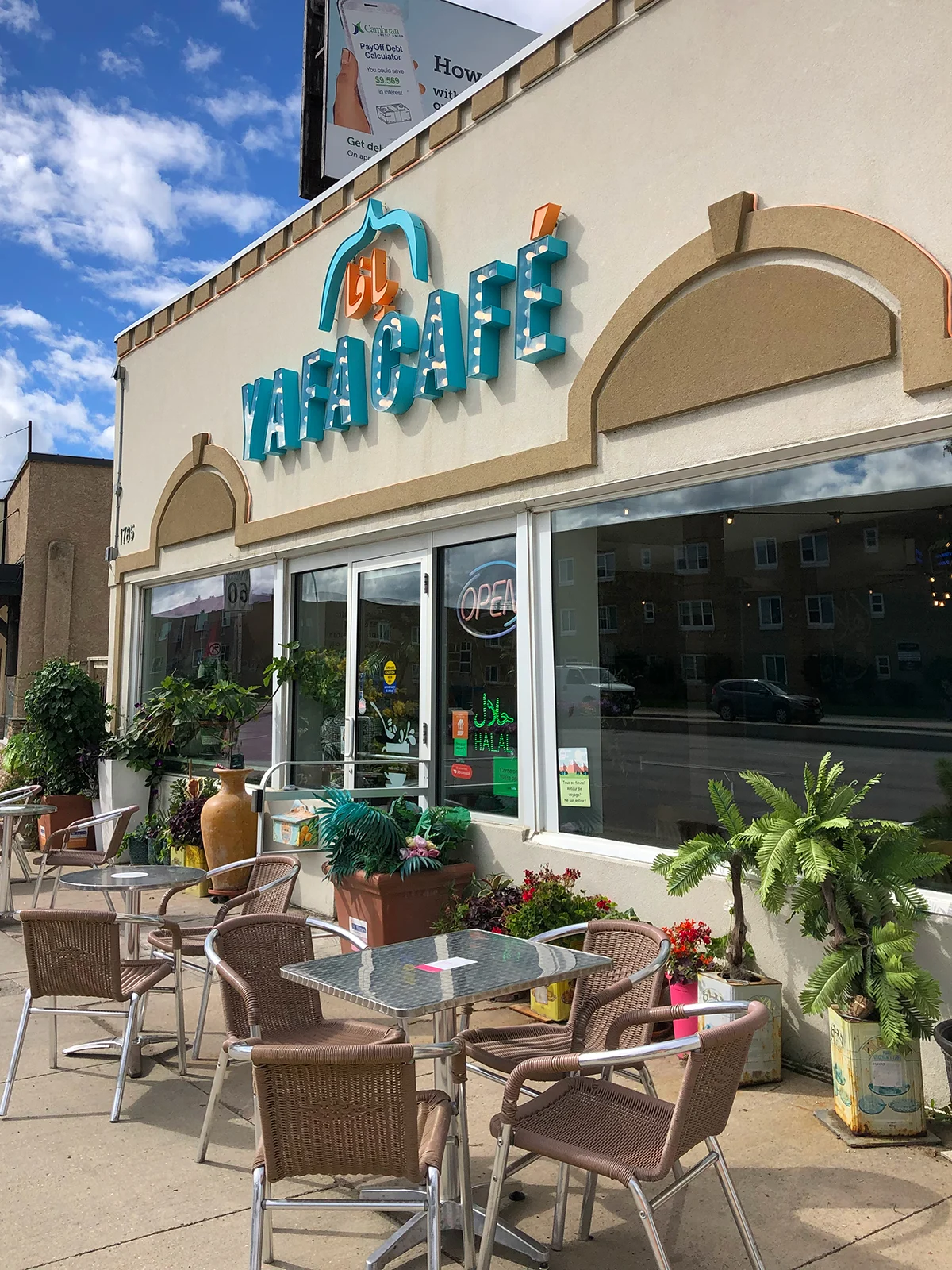 yafa cafe front of building with tables outside and plants