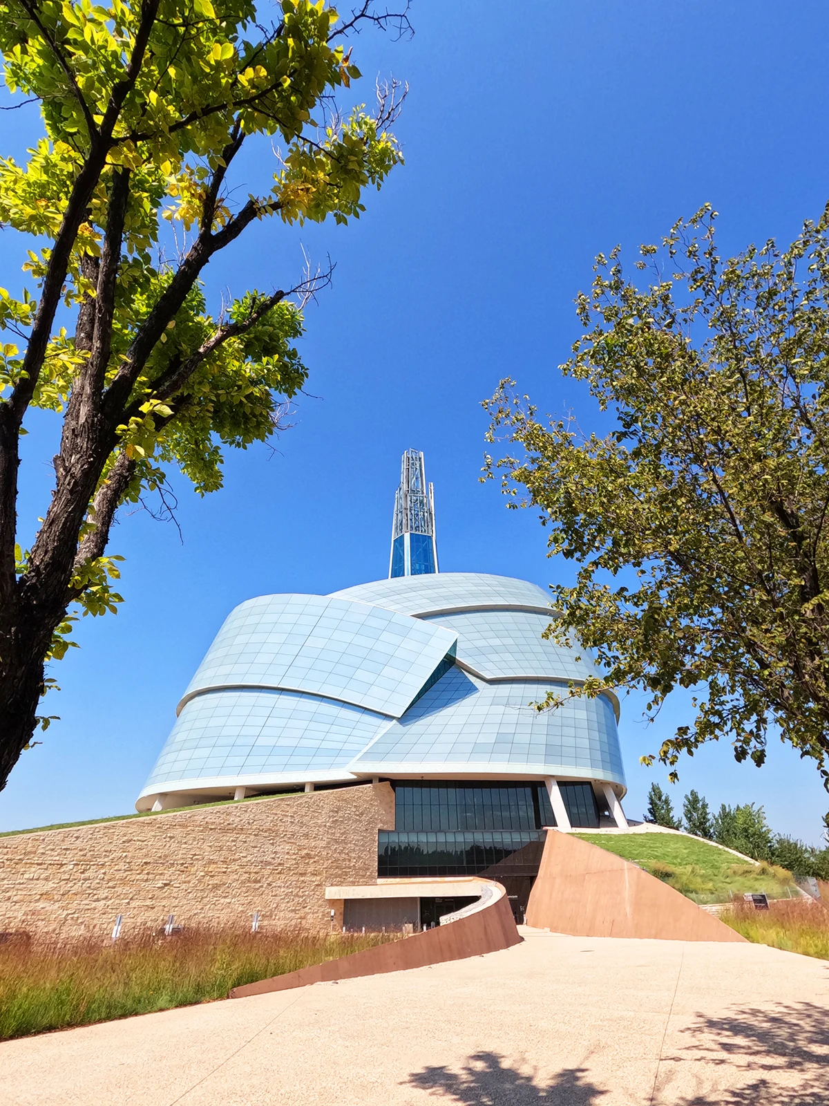 things to do in winnipeg view of the CA human rights museum building exterior with walkway and trees