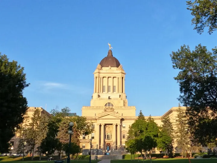 free things to do in winnipeg view of manitoba legislative building with trees at sunset