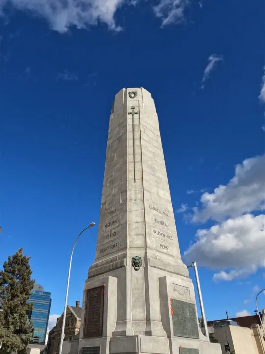 historical marker in downtown winnipeg tall stone structure with carvings and blue sky