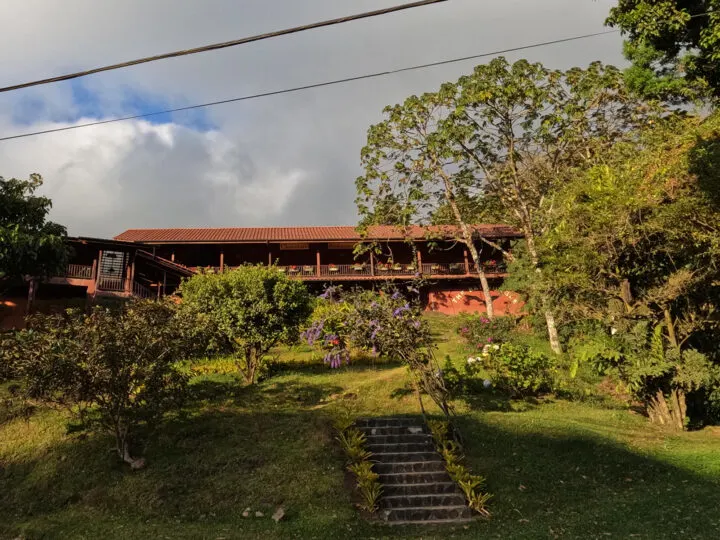 view of two story building upon hill with landscaping