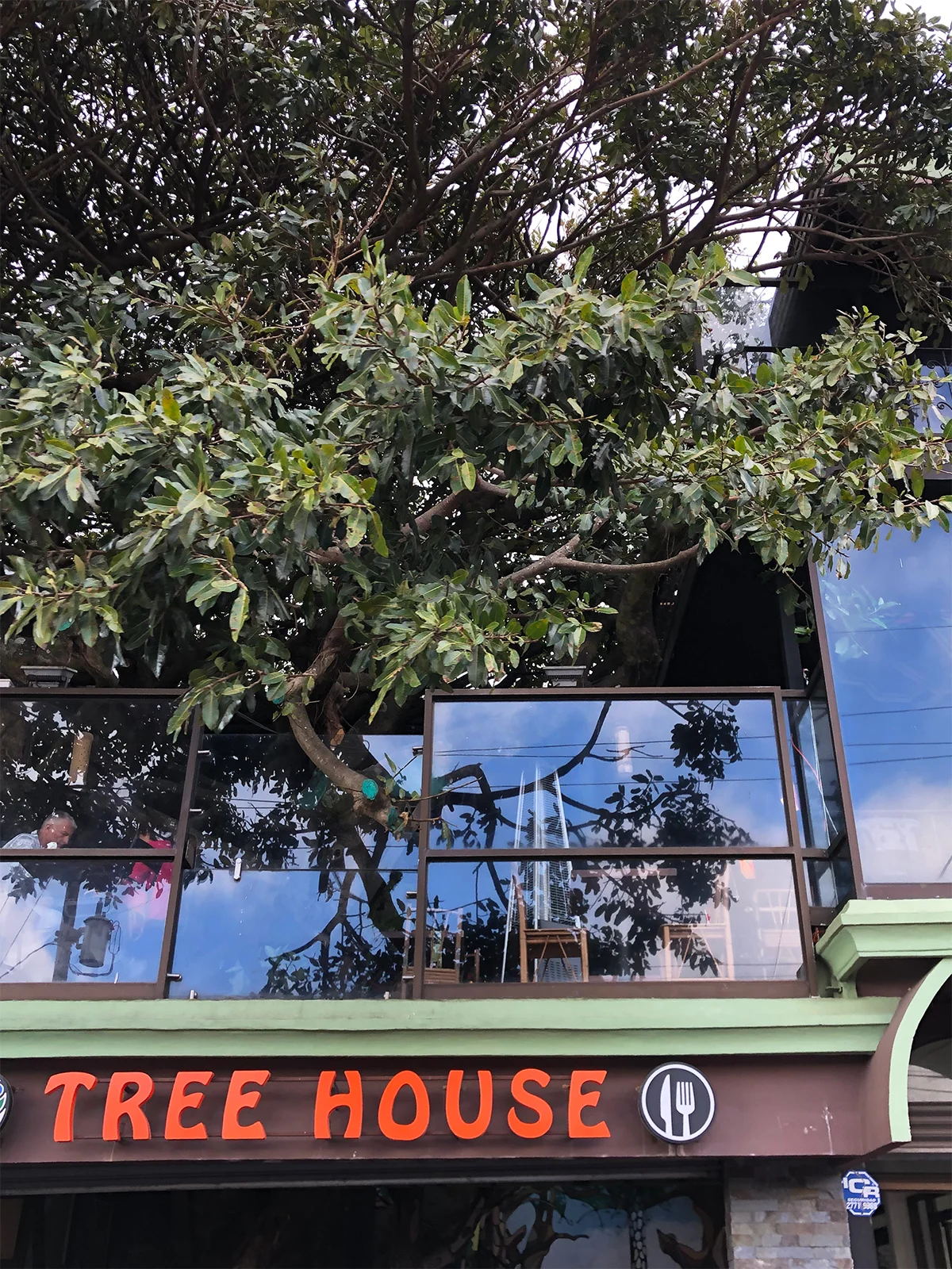 tree house sign with glass panels and tree