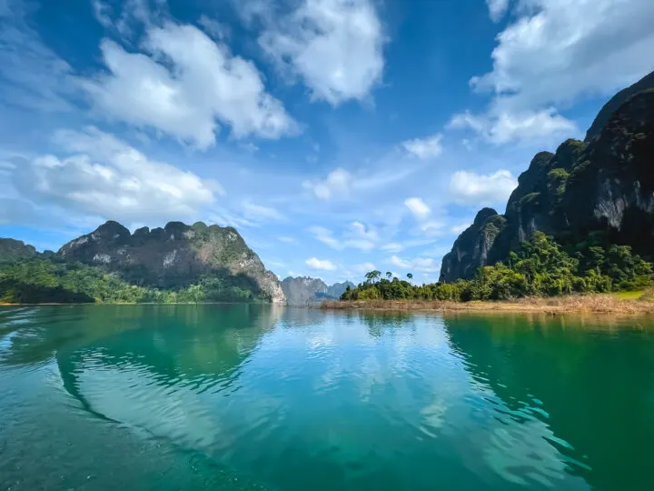 what to do in khao lak day trip to cheow larn lake view of green lake with mountains surrounding it