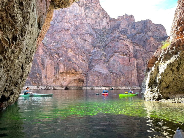lake mead day trips Las Vegas view of cave with green water and kayakers