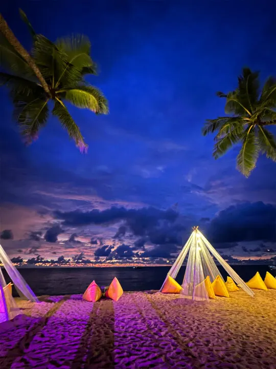 khao lak thailand view of beach with bean bags and palm trees at sunset