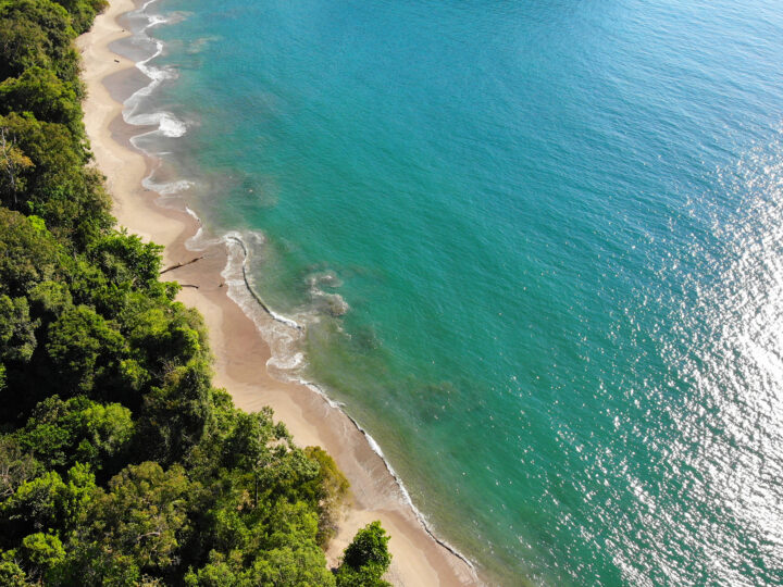 Manuel Antonio Costa Rica view of beach looking down teal water tan sand and trees