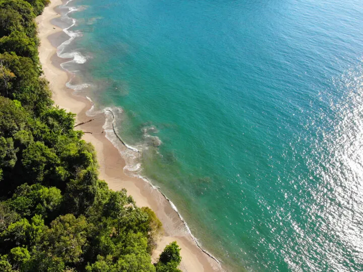 Manuel Antonio Costa Rica view of beach looking down teal water tan sand and trees