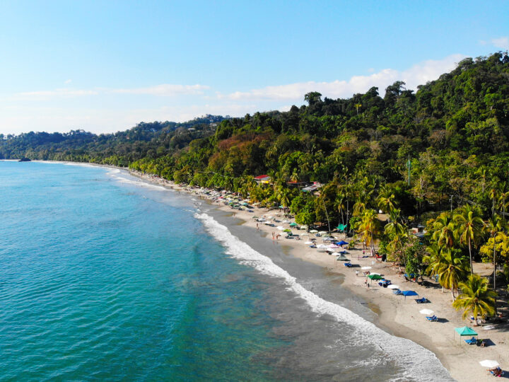things to do in Manuel Antonio Costa Rica view of beach with teal water white waves palm trees and coast