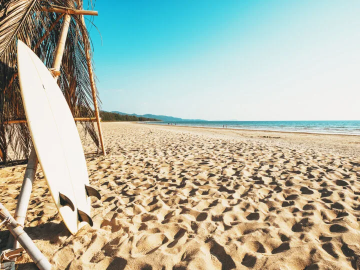 surf board leaning on hut on beach