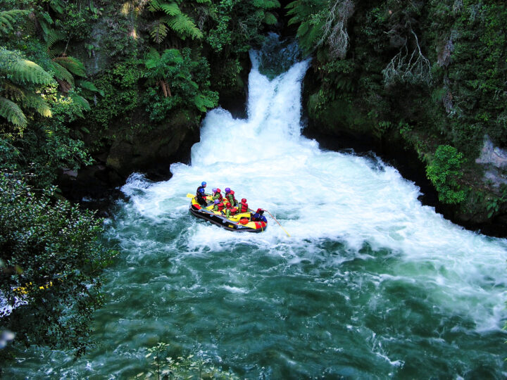 white water raft near with people near waterfall in jungle