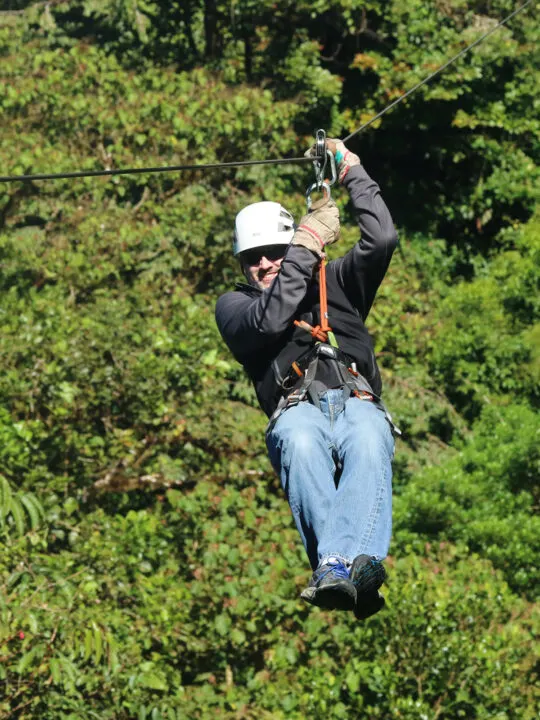 adventures in zipline Manuel Antonio man with jeans and black jacket on zipline