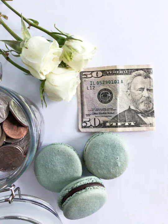 free winter activities view of money on white board with macaroons and flowers