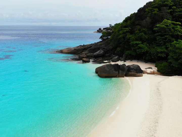 thailand similan islands white sandy beach teal water rocky shoreline