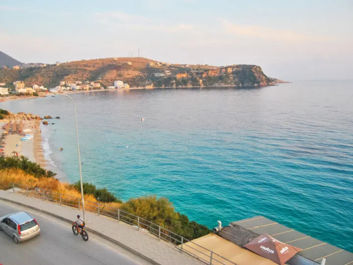 cheap spring break trips for families city of Himara, Albania at dusk view of teal water and coastline