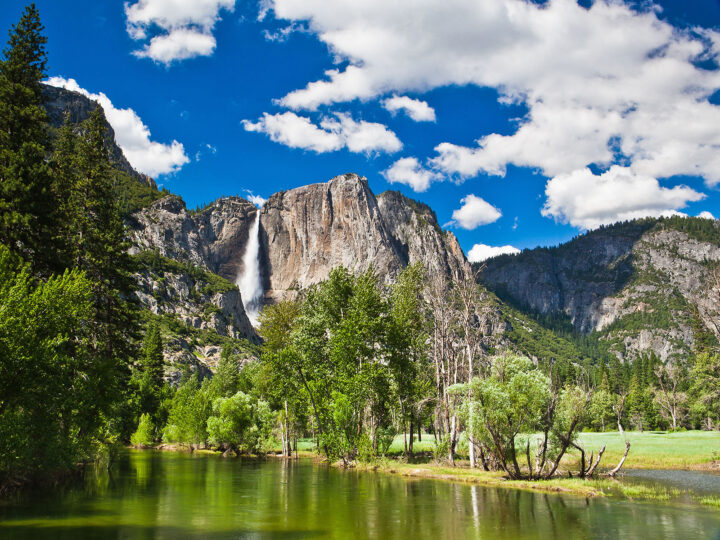 Yosemite national park view of lake trees and rocky cliff with waterfall best spring break destination for families 