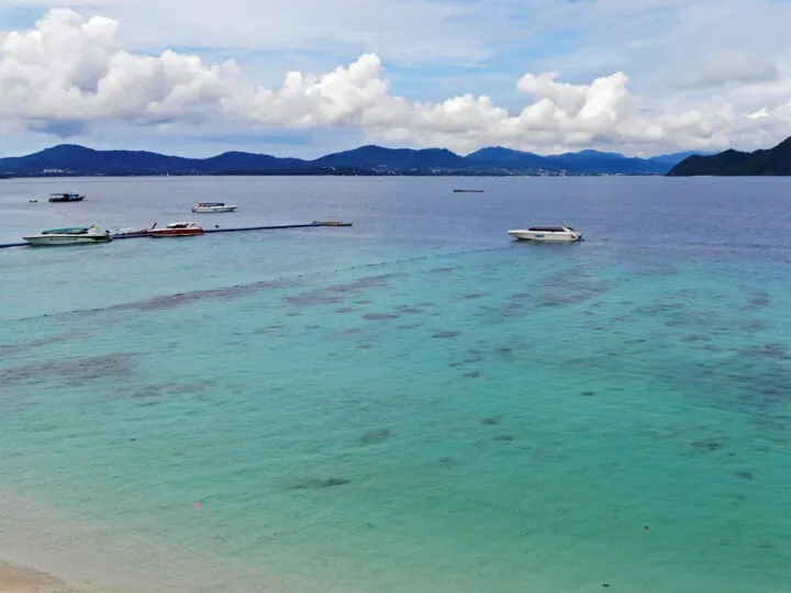 coral island from phuket view of teal water boats and land in distance