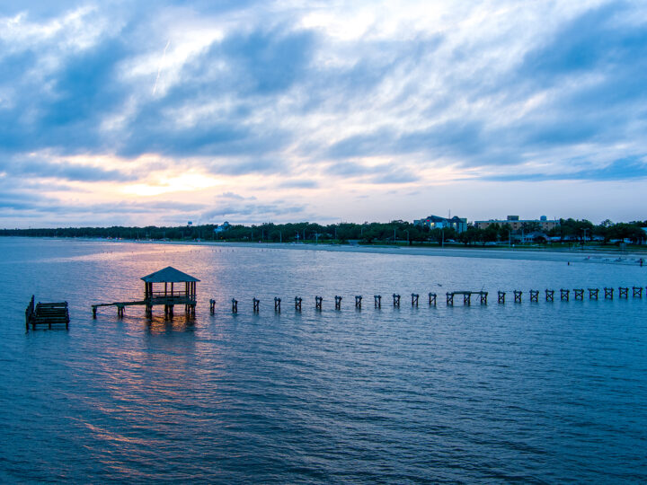 best gulf coast beaches view of pier at sunset with city in distance Biloxi mississippi