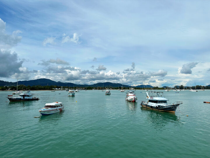 chalong pier phuket with boats in harbor and land in distance