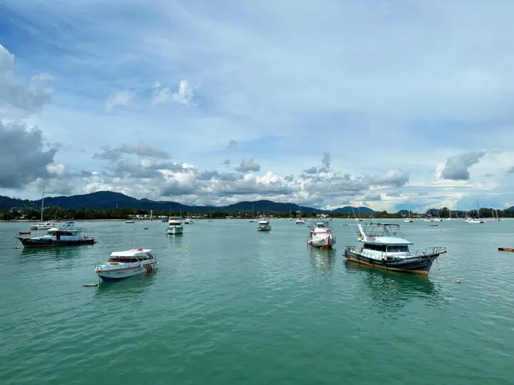 coral island from phuket view of chalong pier with boats in harbor and land in distance