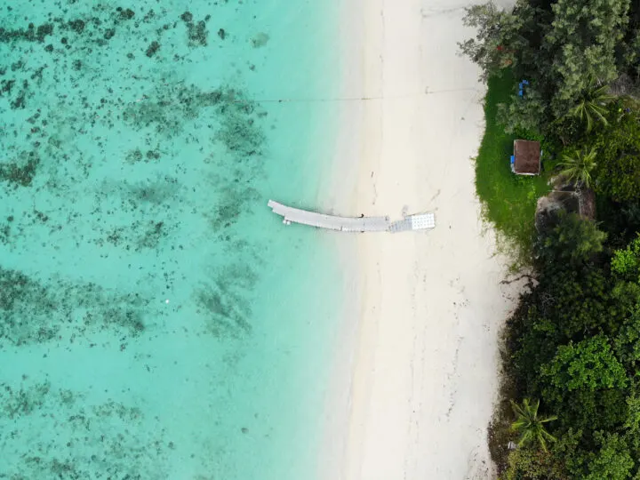 phuket coral island view of teal water white boardwalk sand green coast from above