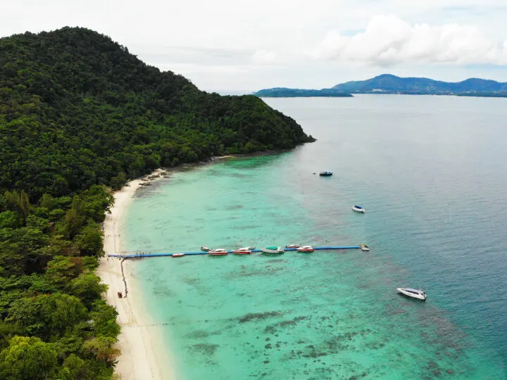 coral island phuket thailand view of azure water white beach pier with boats and island coast